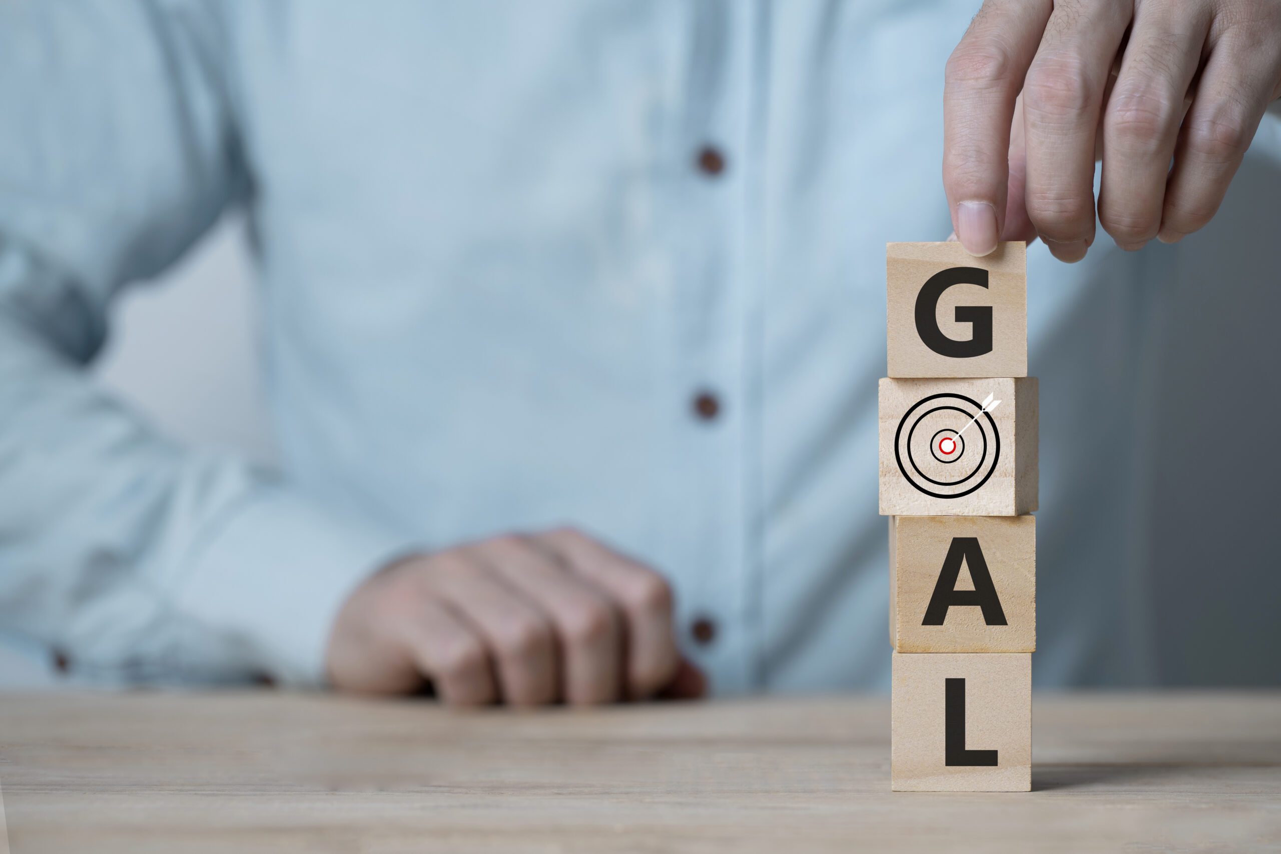 businessman hand arranging wood block with goal word business goals achievement concept key success sustainable development scaled